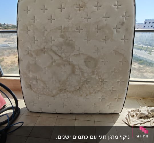 מזרן מלוכלך על רצפה עם צינור ומטלית